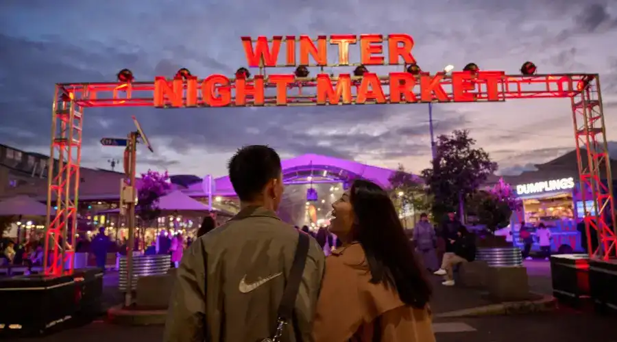 A couple approach the entry to Melbourne’s Queen Victoria Winter Night Market. A couple approach the entry to Melbourne’s Queen Victoria Winter Night Market.