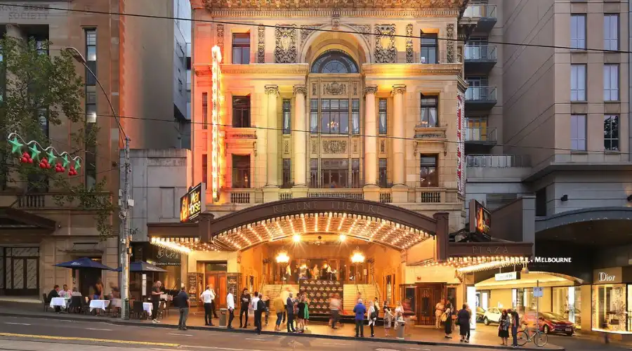 Regent Theatre Melbourne lit up at dusk with visitors arriving for a show. Regent Theatre Melbourne lit up at dusk with visitors arriving for a show.