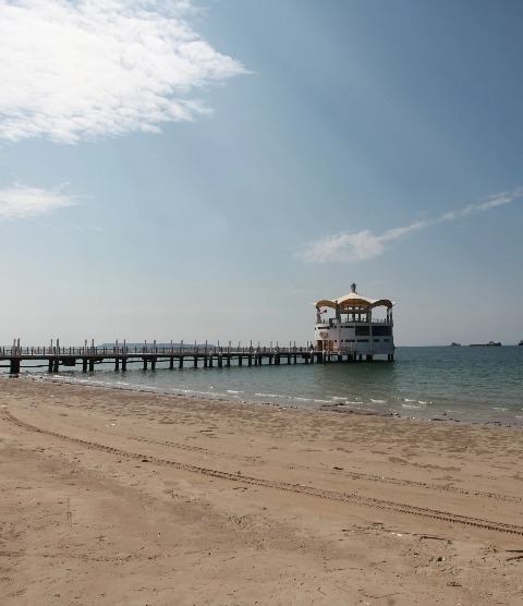 A long wooden pier extends into the ocean in Labuan.