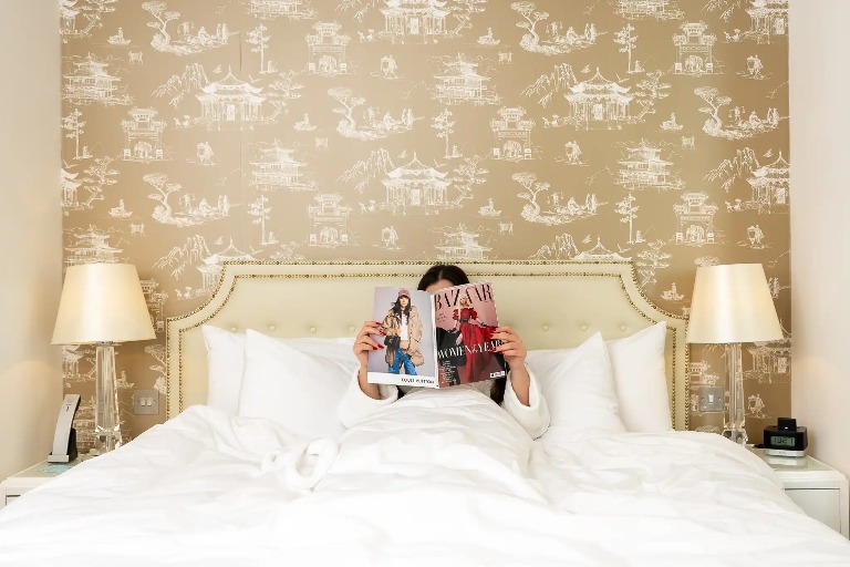 A girl reading a magazine on bed.