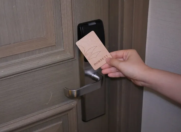 A person trying to open a door using a door key.