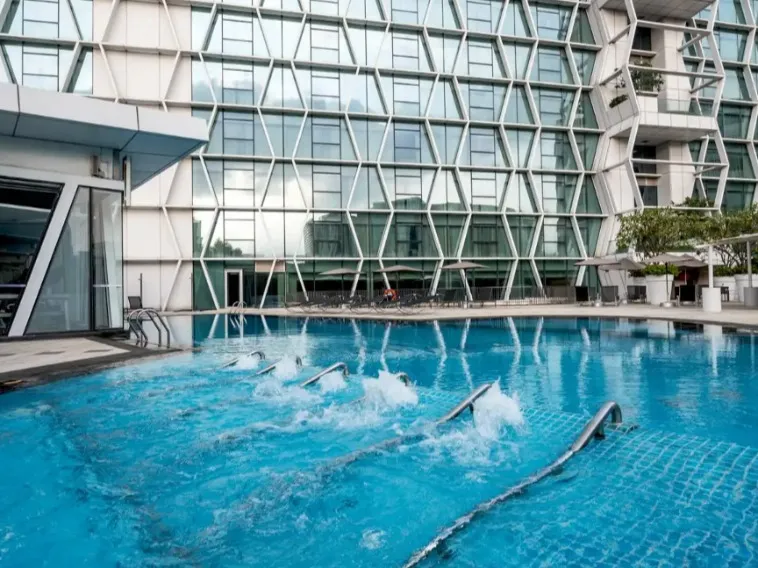 Outdoor pool and glass facades at the Dorsett Changi City Singapore.