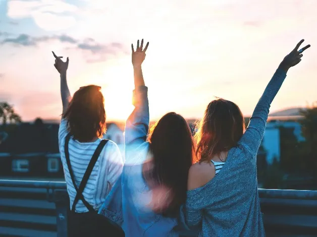 Three girls looking at the Sunset.