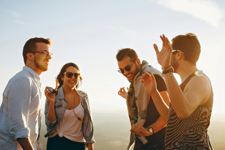 A group of people dancing during a sunset.