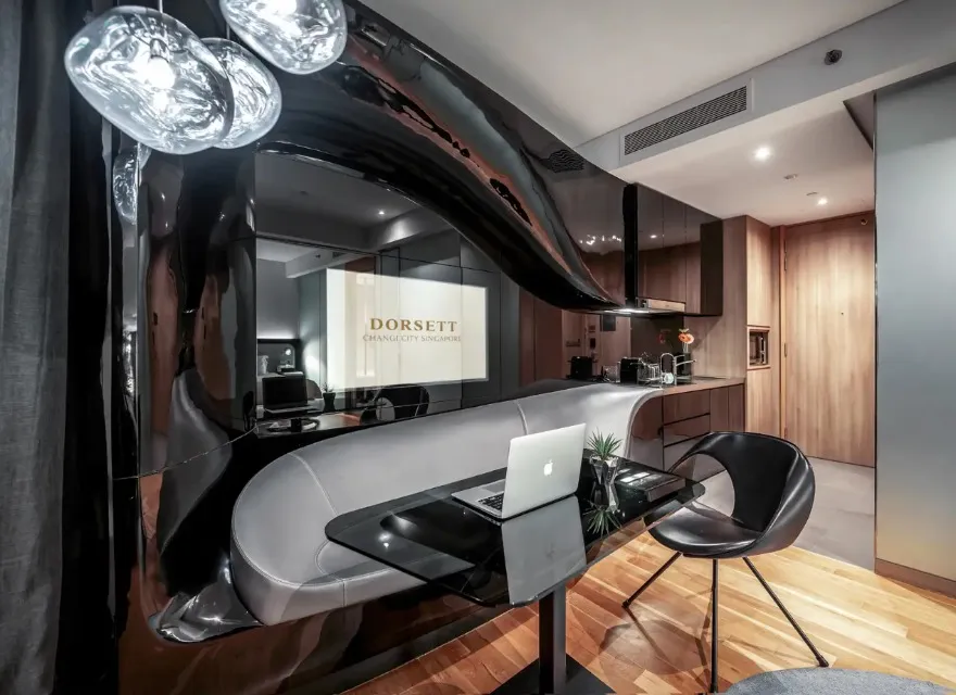 Work desk, TV and sofa adjoining the kitchenette at Dorsett Changi.