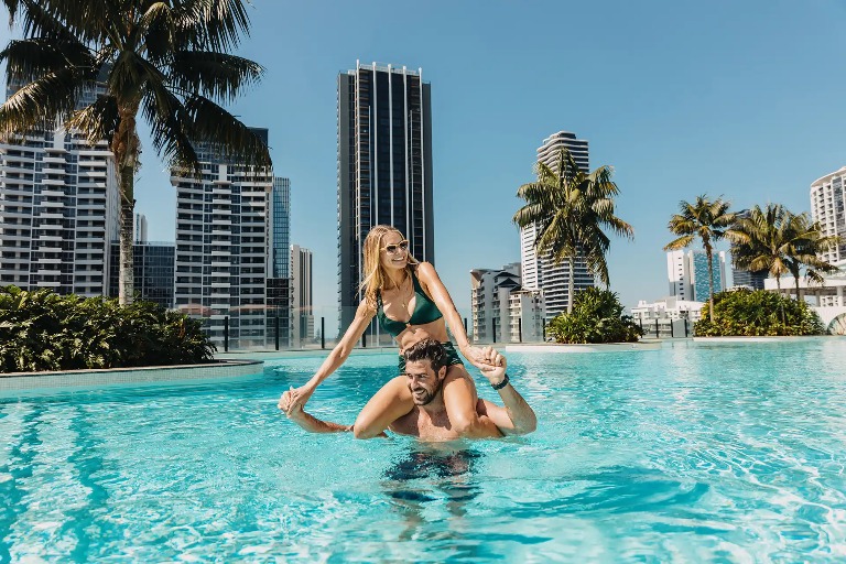 A couple enjoying the rooftop swimming pool at Dorsett Gold Coast