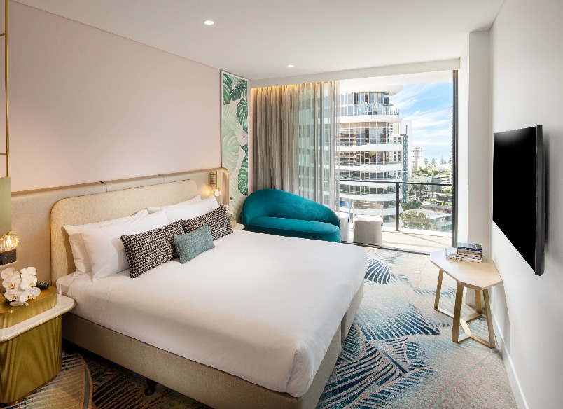 A blue chair by a twin bed at Dorsett Gold Coast Deluxe King Room