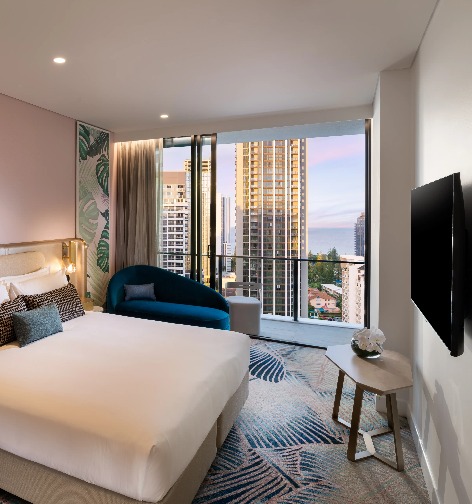 A blue chair by a bed at Dorsett Gold Coast Executive King Room