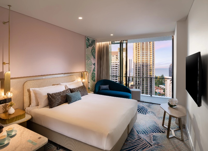 A blue chair by a bed at Dorsett Gold Coast Executive King Room