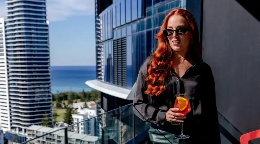 A woman holding a cocktail on the Dorsett Executive Lounge balcony