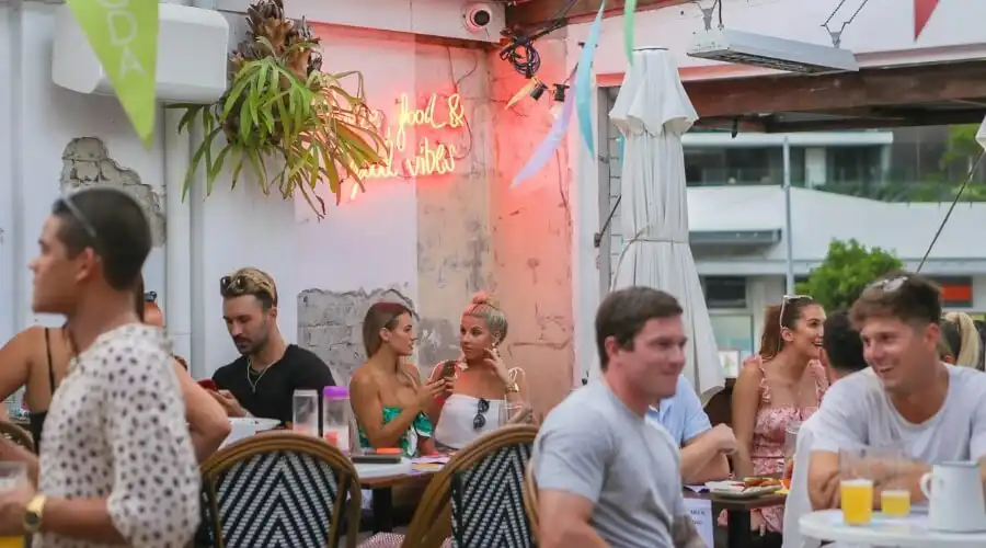 People enjoying drinks and food on the Justin Lane rooftop bar