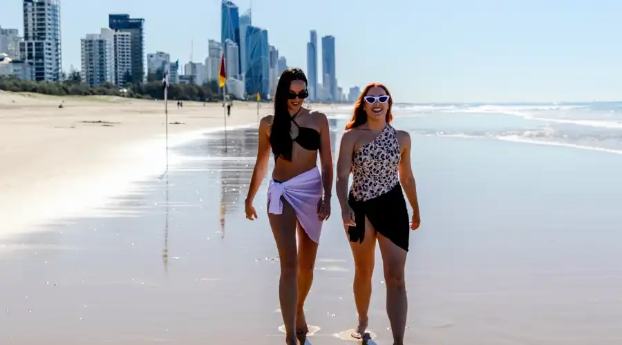 Two women walking along Broadbeach Two women walking along Broadbeach