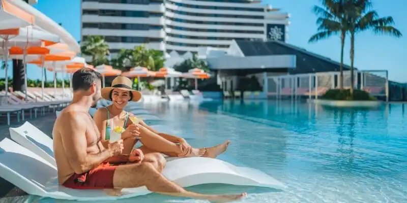 couple on pool loungers at Dorsett Gold Coast couple on pool loungers at Dorsett Gold Coast