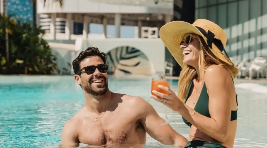 A couple relaxing in the shallow pool area of Isoletto Pool Club with a drink