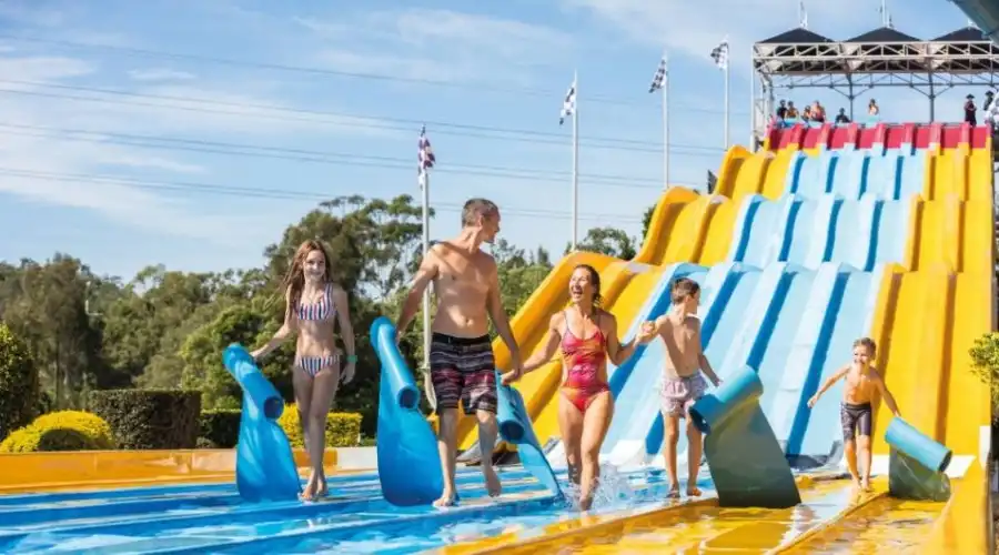 A family happily finishes a slide together at Wet n Wild Gold Coast
                                                                                                                                                                                                                                                                                                                                                                        Credit: Destination Gold Coast