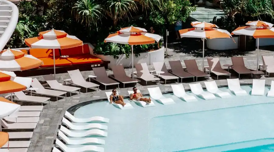 Couple relaxing on wet lounges at Isoletto Pool Club on Christmas morning