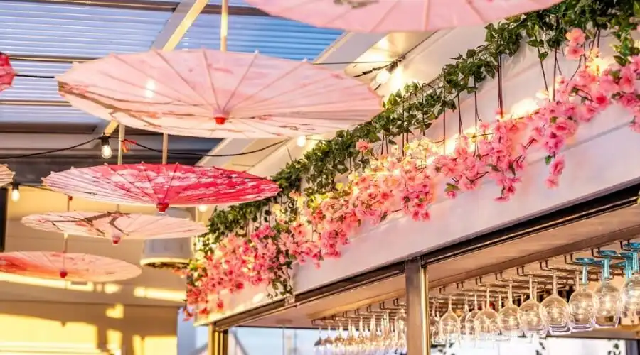 A rooftop bar with pink cherry blossom decor