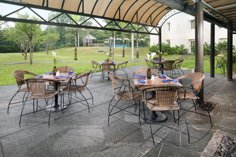 Outdoor seating by the garden at Dorsett Grand Subang.