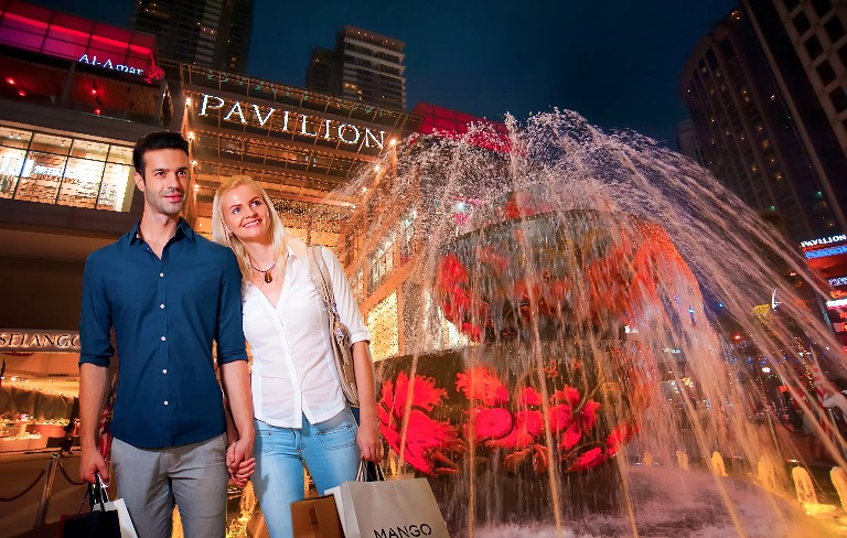 A couple next to a pond with red lighting.