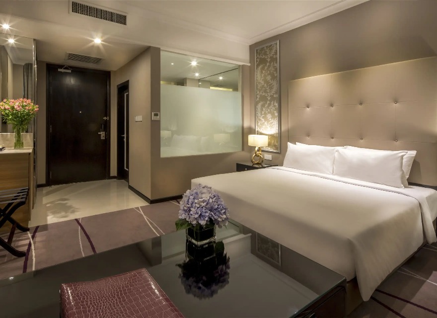 Bed and bathroom in a Dorsett Hartamas Kuala Lumpur bedroom.