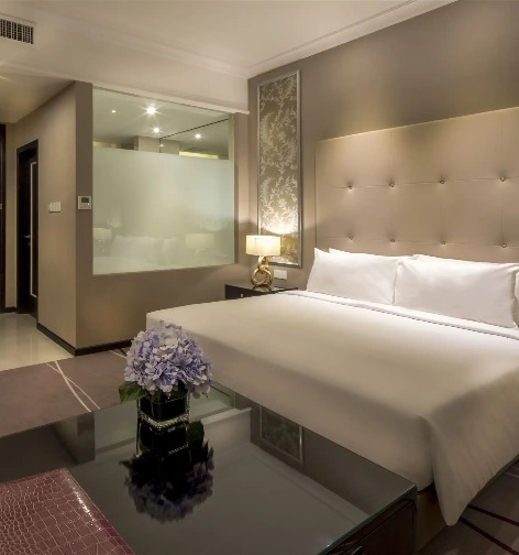 Bed and bathroom in a Dorsett Hartamas Kuala Lumpur bedroom.