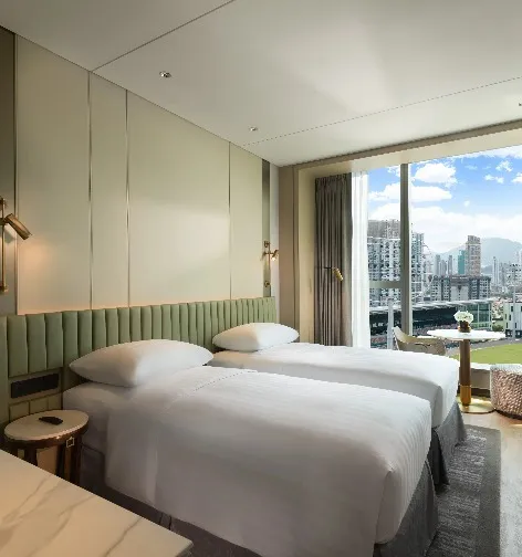 Single beds overlooking the Kai Tak Sports Park.