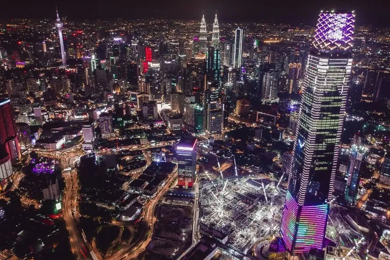 Skyscrapers and buildings with lights in Kuala Lumpur during the night.