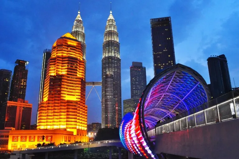 Petronas Twin Towers and a futuristic-looking bridge in the foreground.