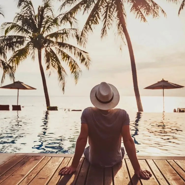 Man by the pool enjoying the sunset.