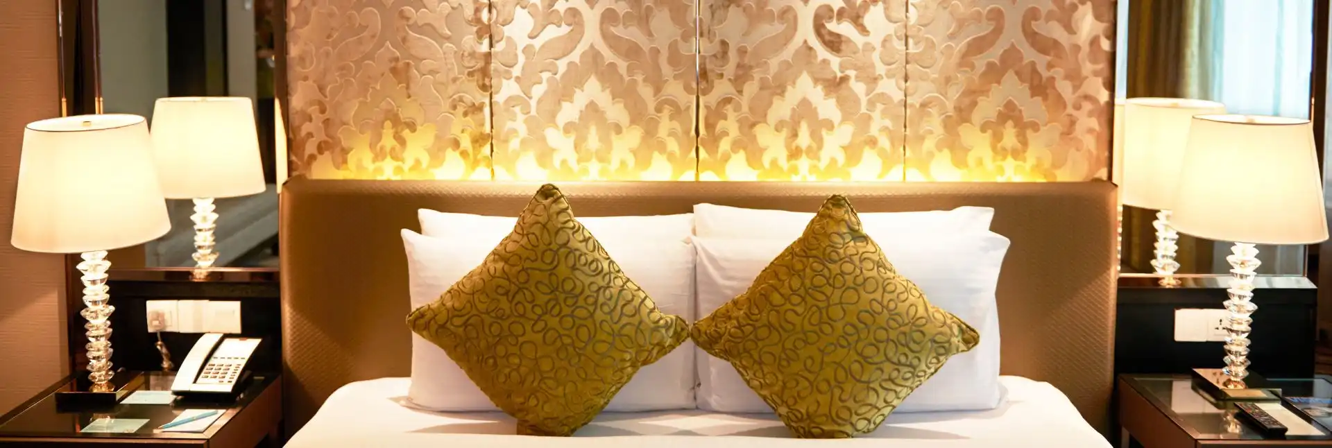 Pillows and bedside lamps in a Dorsett Kuala Lumpur bedroom. 