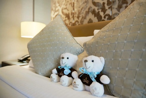 Two teddy bears in a Dorsett Kuala Lumpur bedroom.