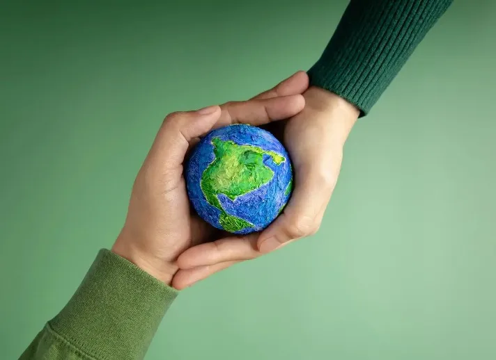 Two people holding a planet earth themed ball.