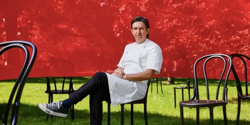 Chef Andrew McConnell sitting in front of a red backdrop Chef Andrew McConnell sitting in front of a red backdrop