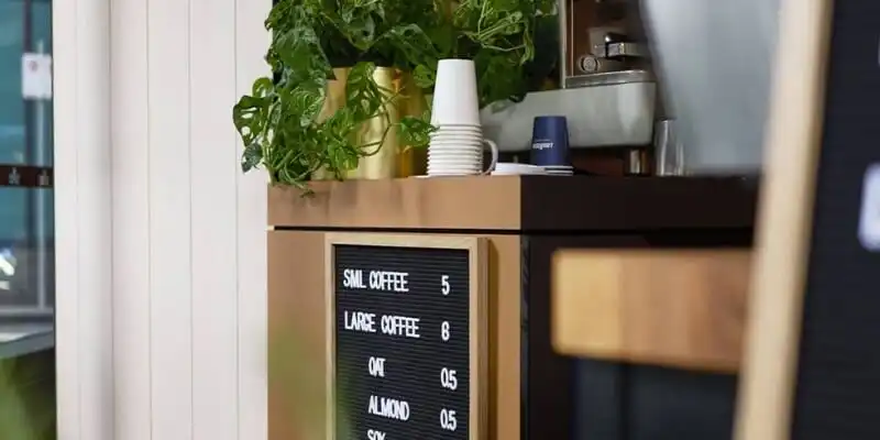  Coffee window with a green plant and a black menu