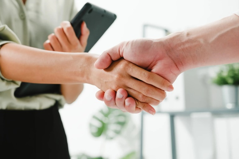 Two individuals engage in the act of shaking hands.