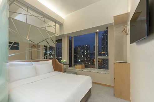 Queen-size bed with a city view at Room Executive, Dorsett Mongkok