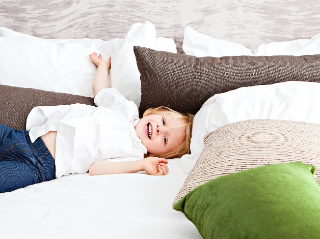 A kid rests on a bed at  Dorsett Mongkok Hotel, Hong Kong