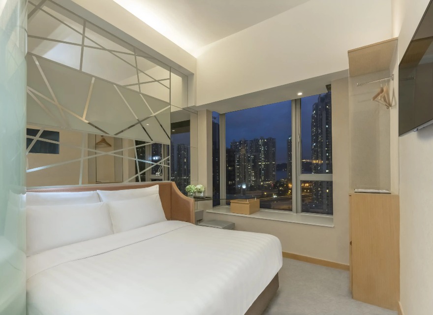 Queen-size bed with a city view at Room Executive, Dorsett Mongkok