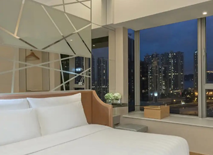 Queen-size bed with a city view at Room Executive, Dorsett Mongkok