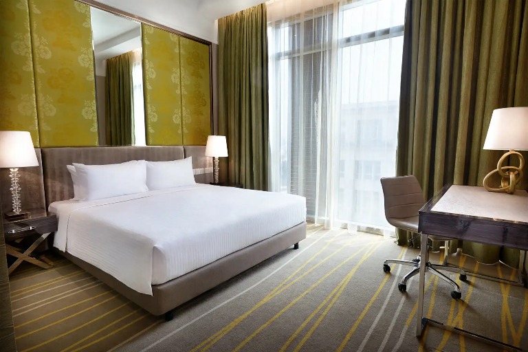 King bed and a work desk in a Dorsett Putrajaya Hotel room.