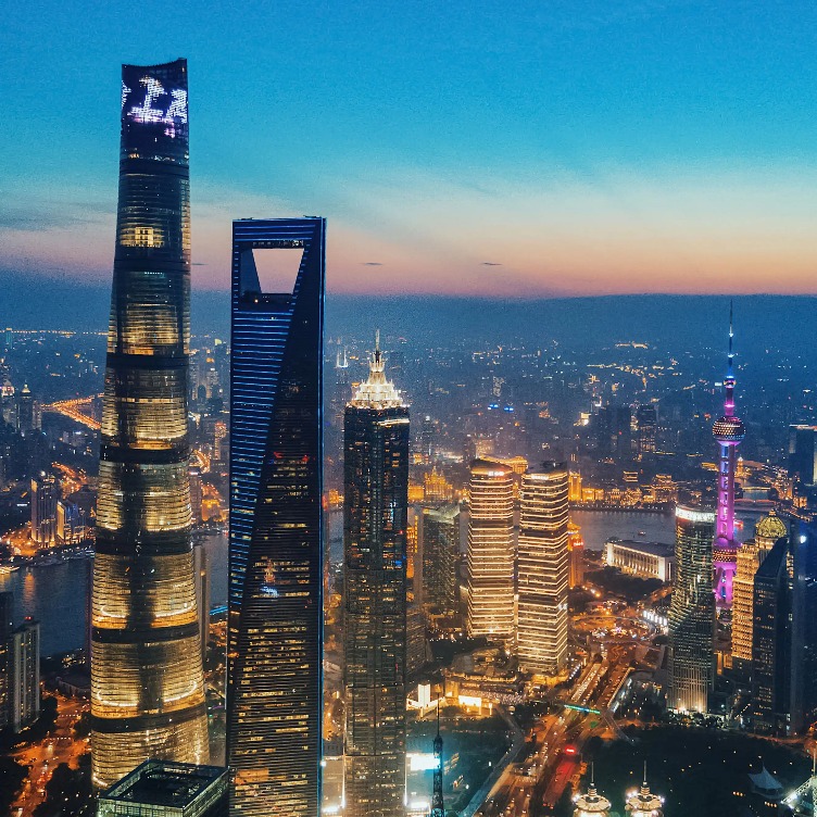 Buildings with warm lighting on the exterior at night.