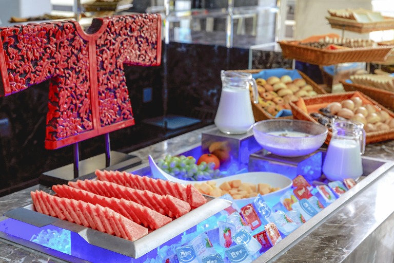 Fruits, baked goods and juice items on a platter.