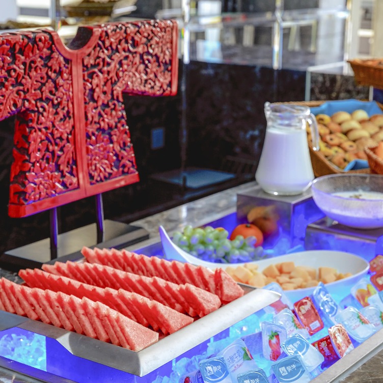 Fruits, baked goods and juice items on a platter.