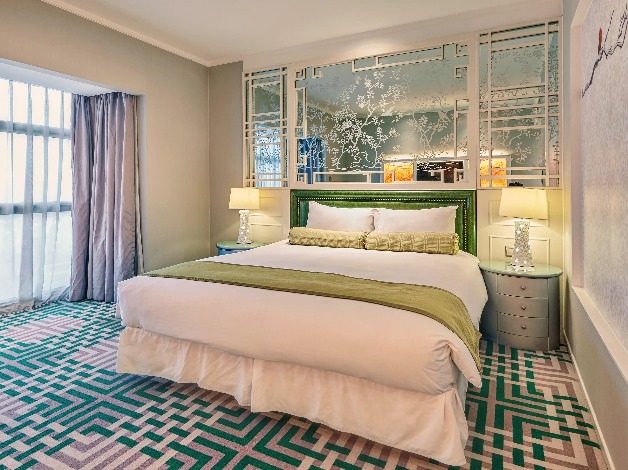 King bed by the window and lamps in a Dorsett Shanghai Hotel Room.