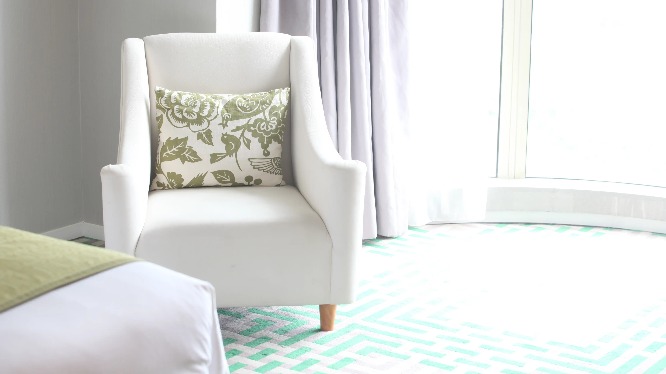 White couch and green cushion in a Dorsett Shanghai Hotel bedroom.