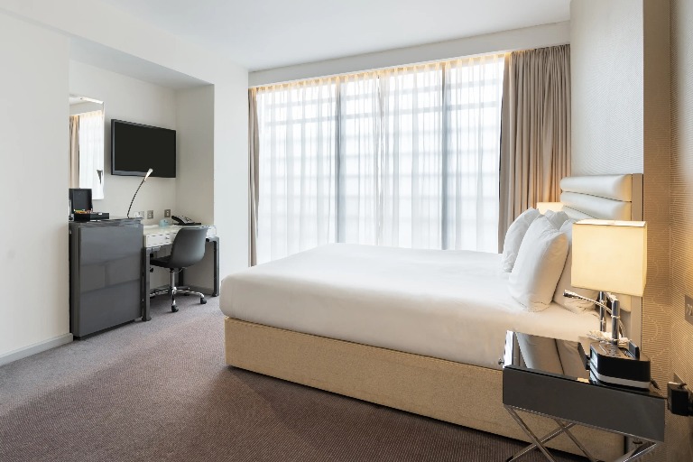 Twin bed, TV, and work desk in Dorsett Shepherds Bush Executive Room.