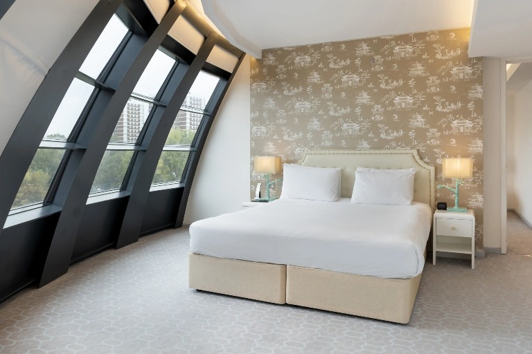 King-size bed with bedside tables in Dorsett Suite, London.