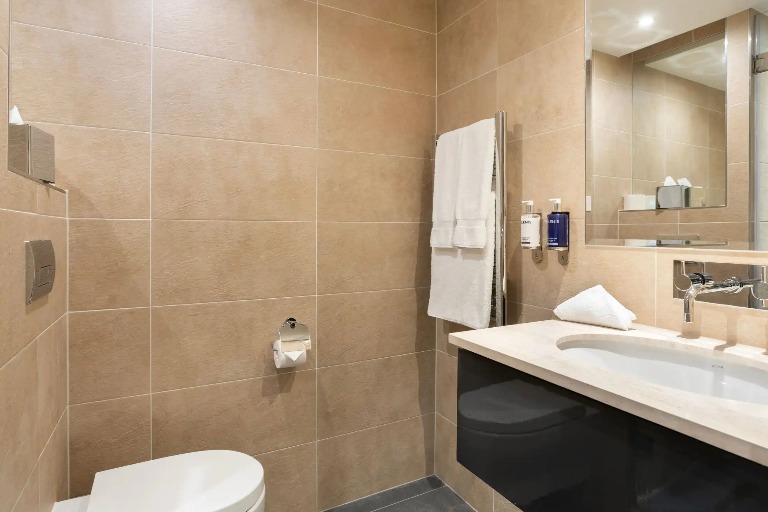 A towel rack next to a single vanity at Dorsett Shepherd Bush London.