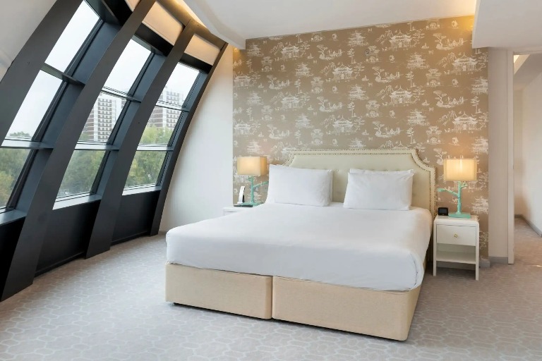 King-size bed with bedside tables in Dorsett Suite, London.