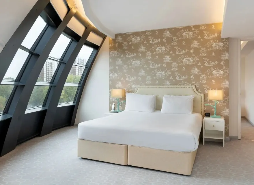 King-size bed with bedside tables in Dorsett Suite, London.